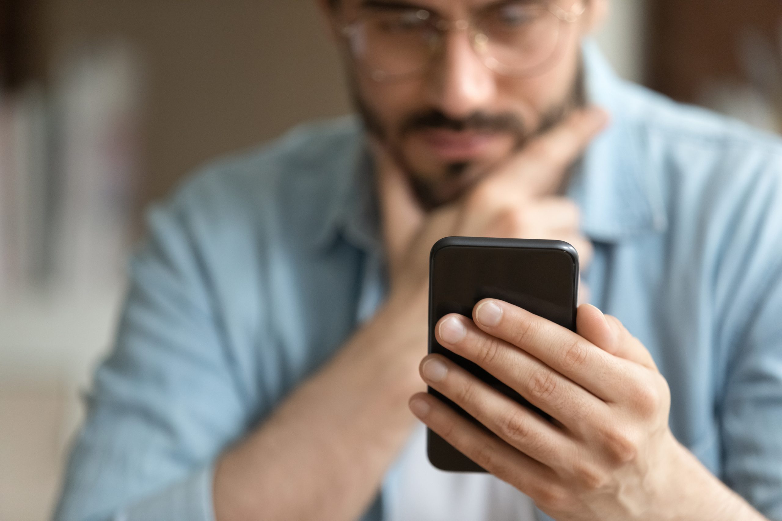 Crop close up of man hold modern smartphone gadget look at screen text or message online. Caucasian male use cellphone browse surf wireless internet on device. Communication, technology concept.